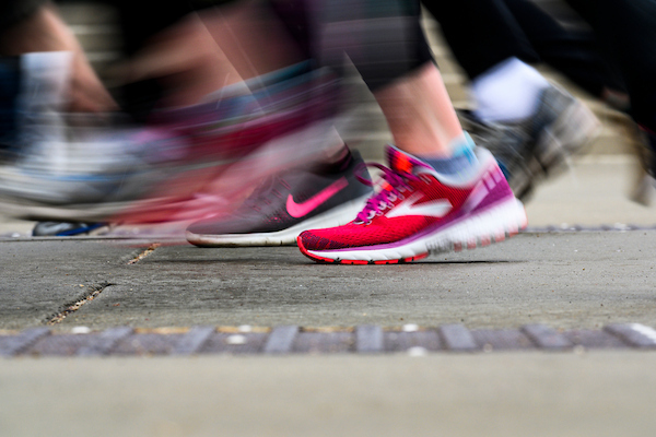 A sea of blurred shoes pound the pavement as participants run along Langdon Street