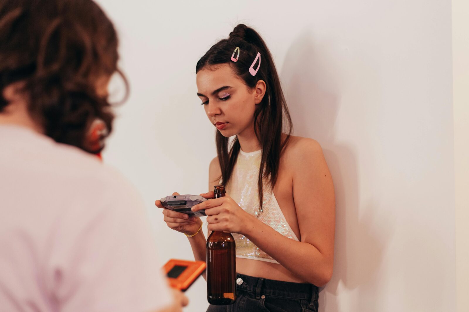 Woman in crop top playing a handheld video game
