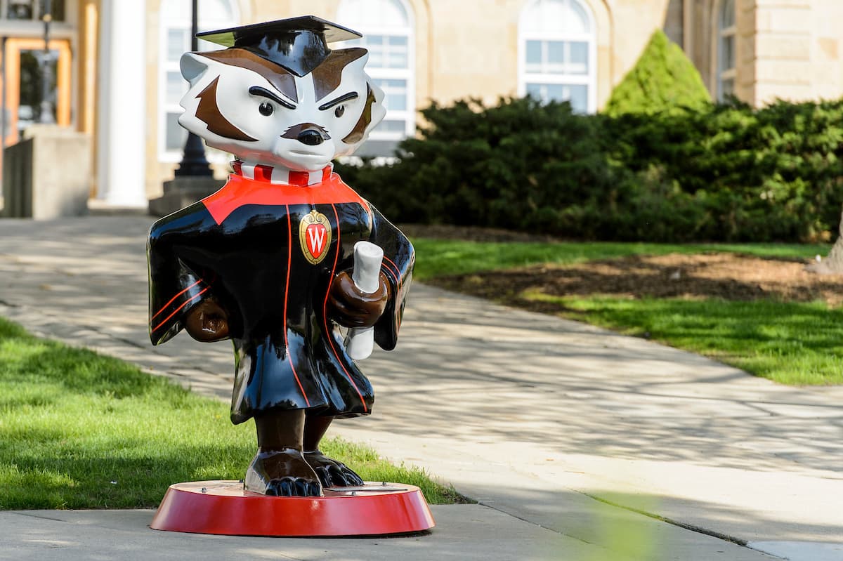 Statue of Bucky in a graduation cap and grown at a wide aspect ratio.  Bucky is off center to the left of the frame. 